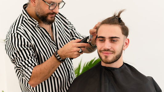 Barber blending the side of a fade with clippers
