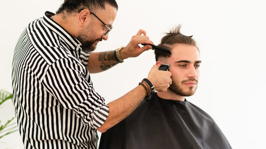 Barber laying a clipper guideline on the side of the head