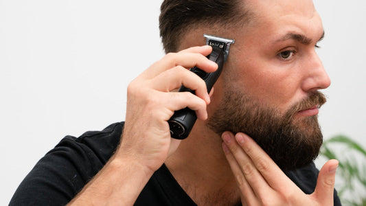 Man lining up his own jaw and beard edge with a trimmer